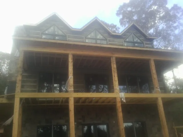 Dormers and porch framing on a large log home under construction — Roof Coating work by our crew in Crawfordsville