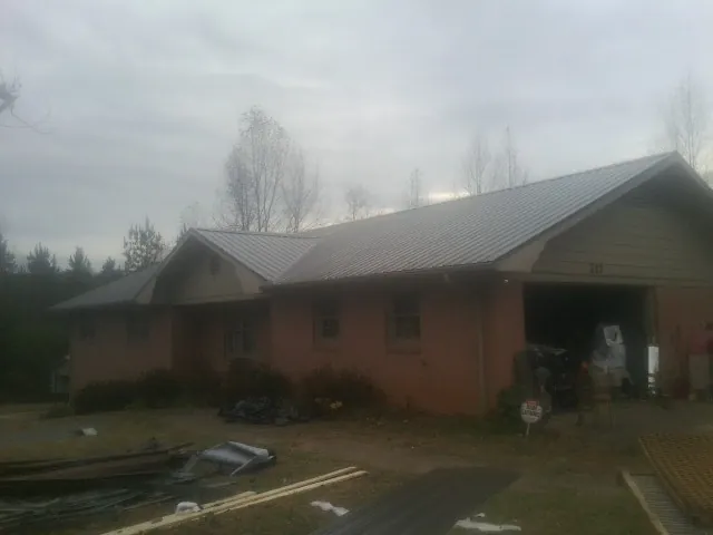 Gray metal roof on a stucco house with an attached garage in Crawfordsville