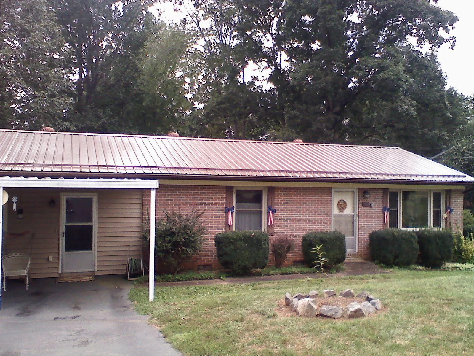 Bronze metal roof and carport on a brick ranch home — Roof Repair work by our crew in Crawfordsville